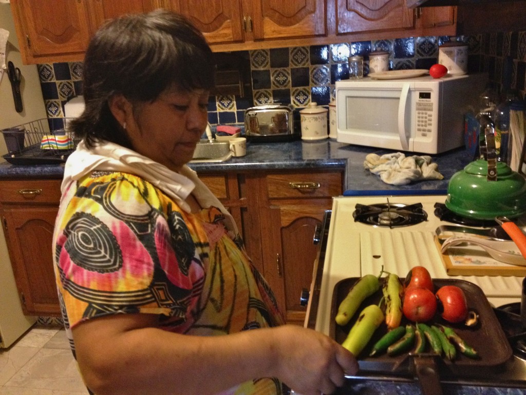 Woman in kitchen roasting vegetables on pan