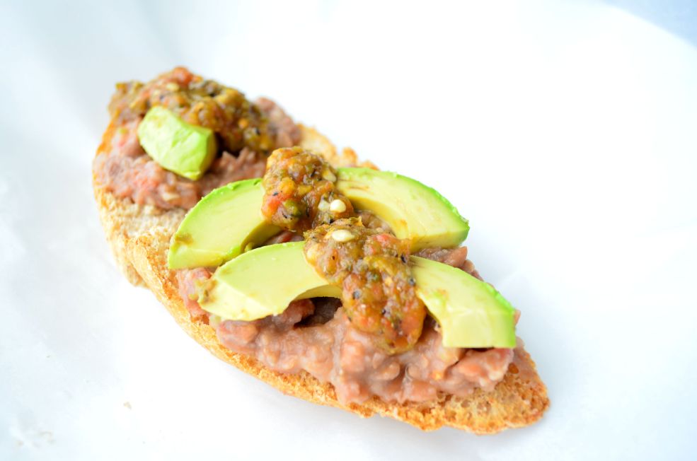 Spicy Bean Avocado Toast (molletes) is perfect for breakfast with toast slathered in refried beans, avocado slices, and salsa molcajeteada.