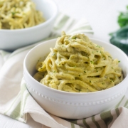 spaghetti on green poblano sauce in a white bowl