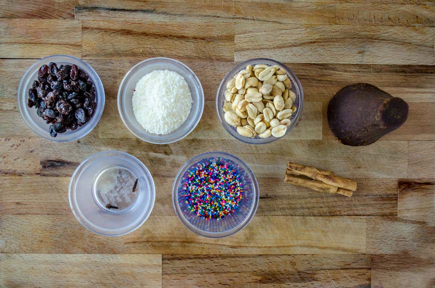 Small glass bowls with sprinkles, peanuts, raisins, and other small ingredients.