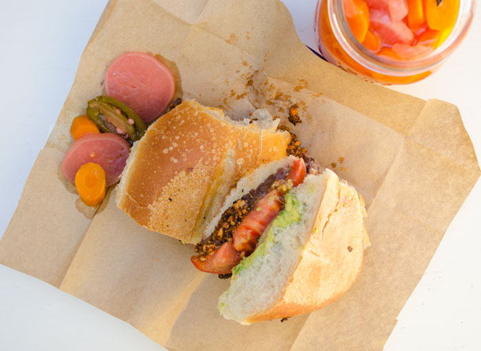 Top view of a vegan chorizo torta on brown paper on a white counter.