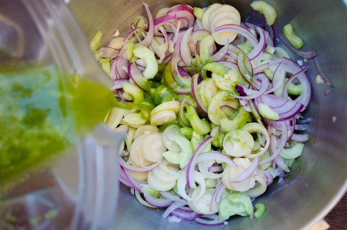 A blender pouring chile sauce over hearts of palm ceviche.