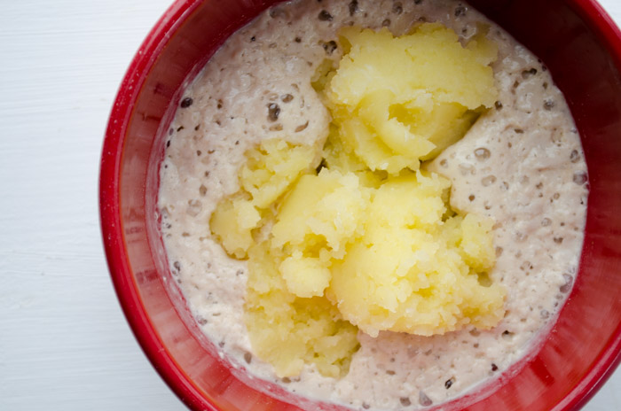 Mashed potato mixed with the yeast mixture in red bowl