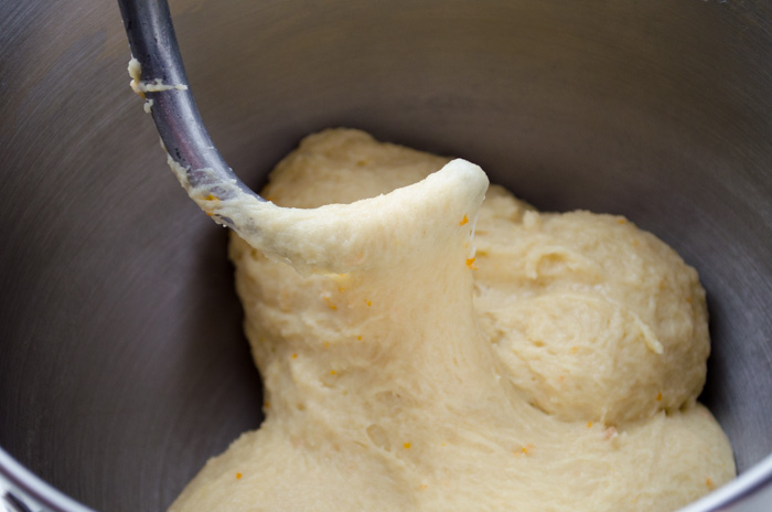 Dough hook inserted into dough to show stretchy consistency