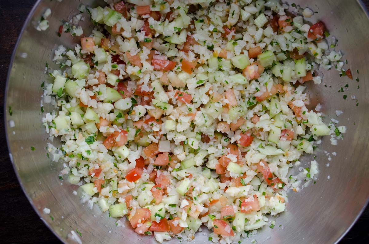 Top view of a metal mixing bowl filled with cauliflower ceviche.