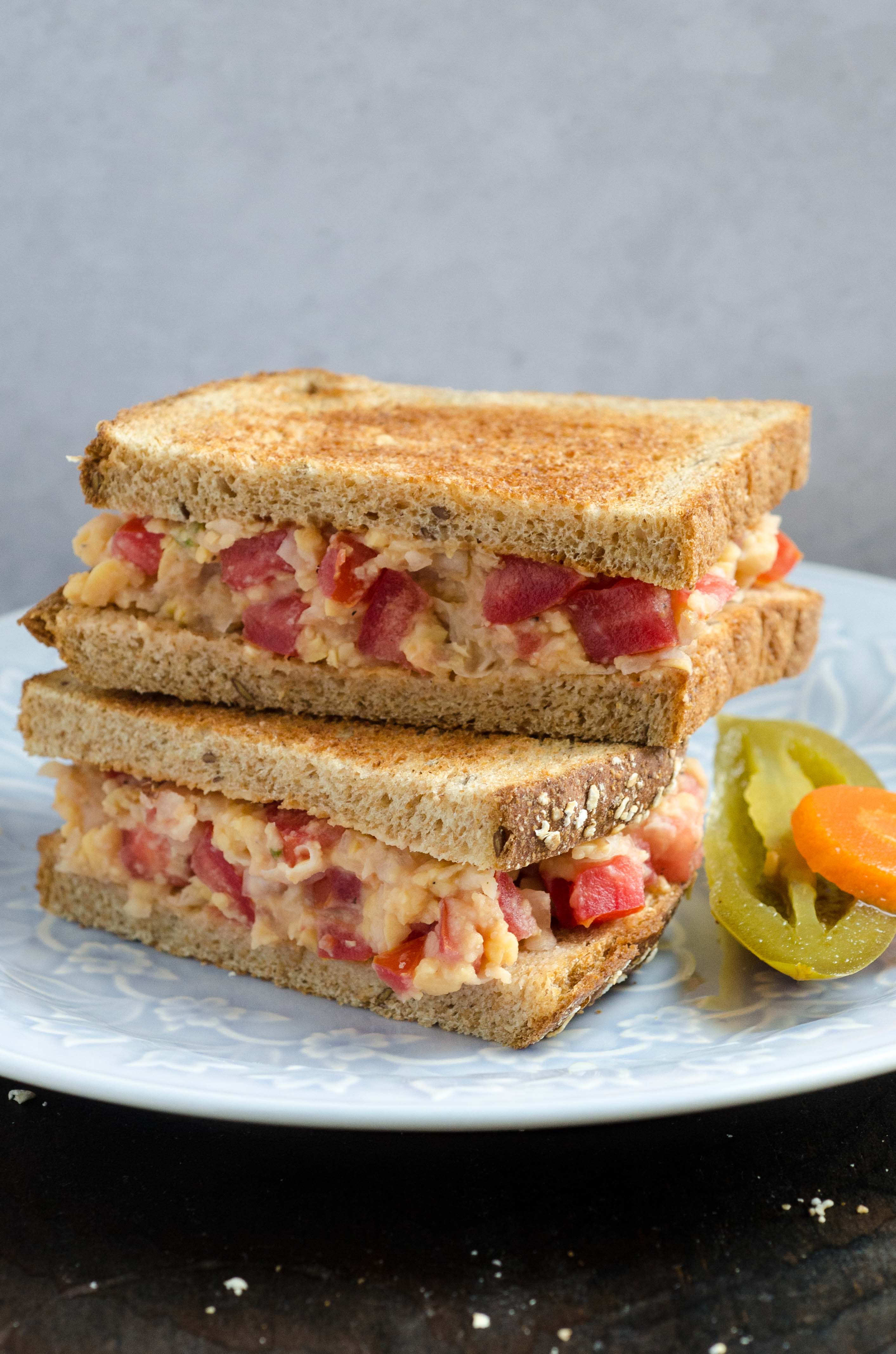 Mexican Vegan "Tuna" Salad sandwich cut in half on a white dinner plate.