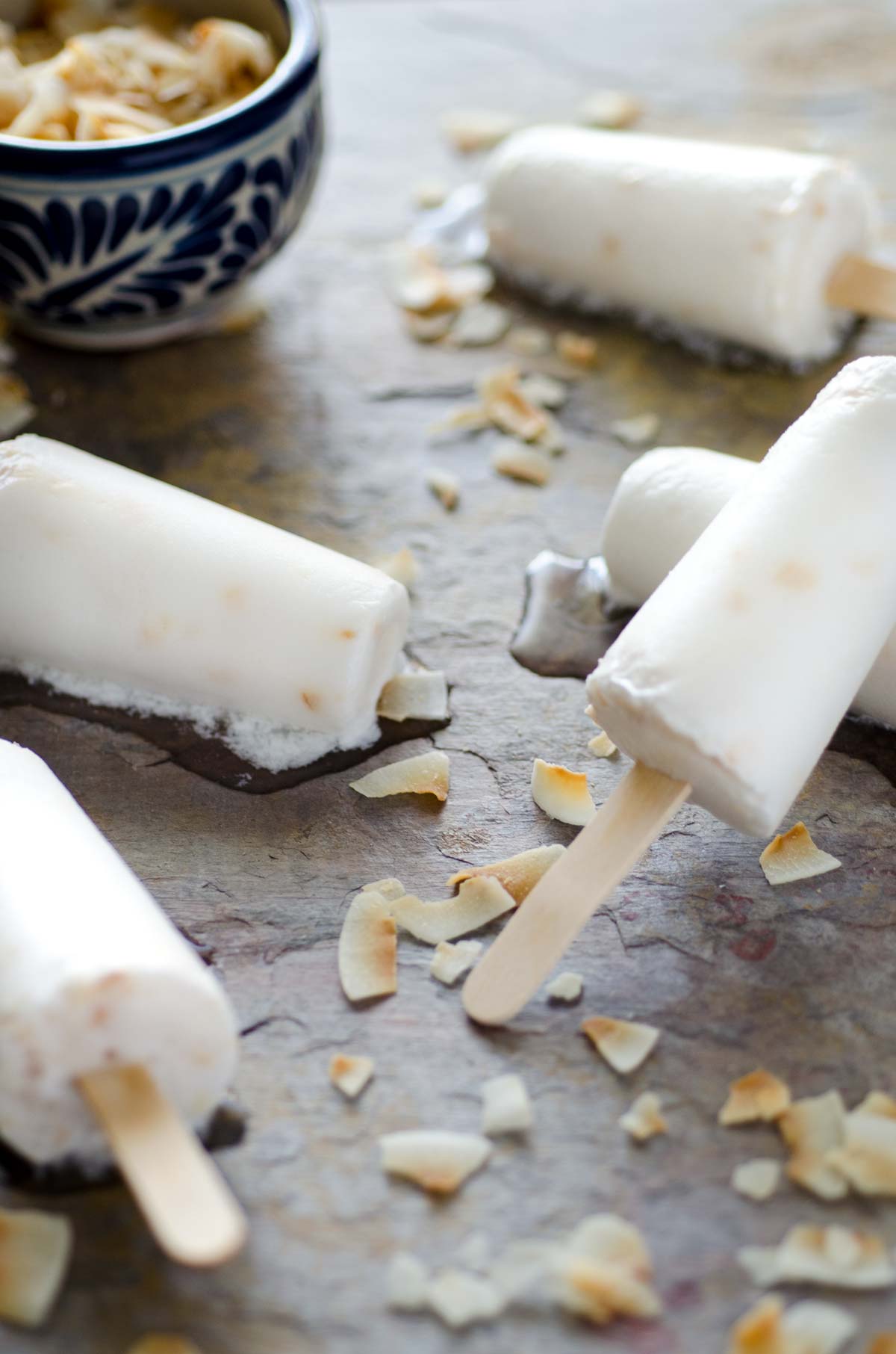 Vegan coconut paletas on a stone surface.