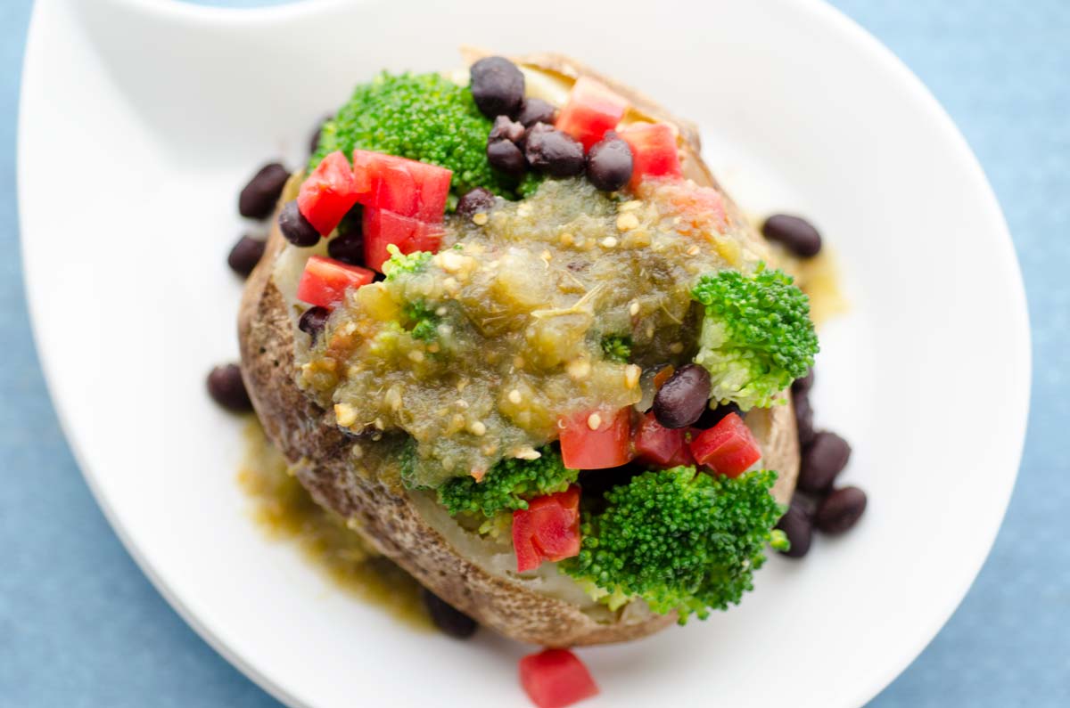 Top view of a Mexican stuffed loaded baked potato in a white bowl.