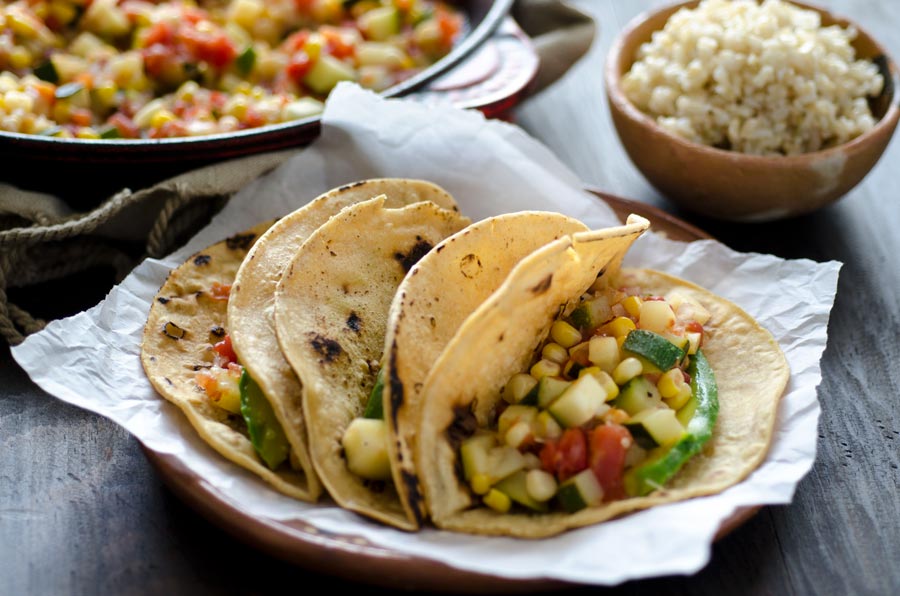 Calabacitas tacos are tender zucchini, ripe tomatoes, sweet corn, and garlic stewed together to make a satisfying, finger licking taco.