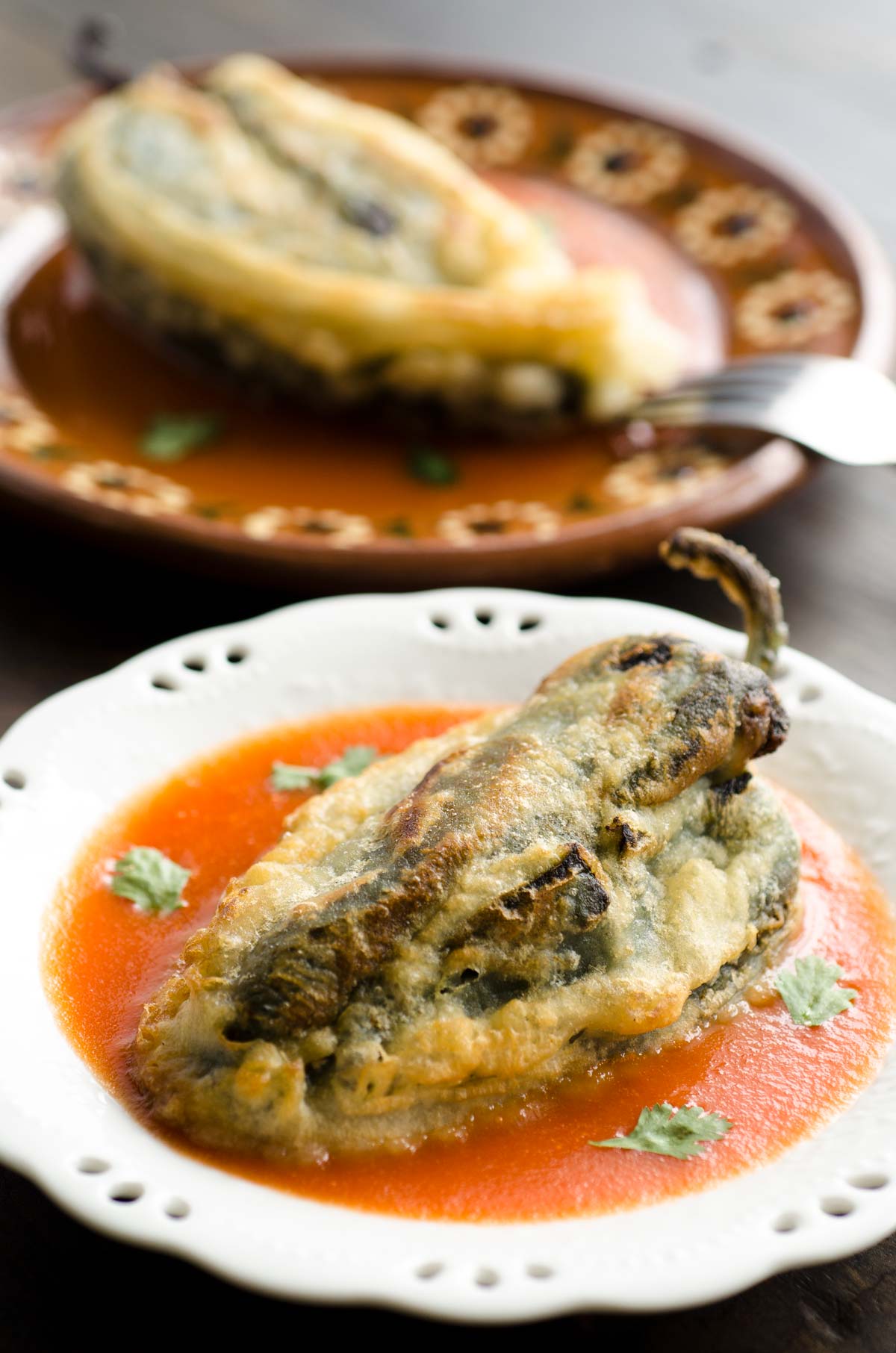 This recipe for vegan chiles rellenos is truly fantastic! They are crispy, melty, spicy and served on a garlicky tomato sauce.