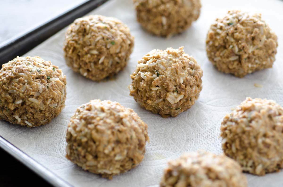 Vegan meatballs on a parchment lined baking sheet.