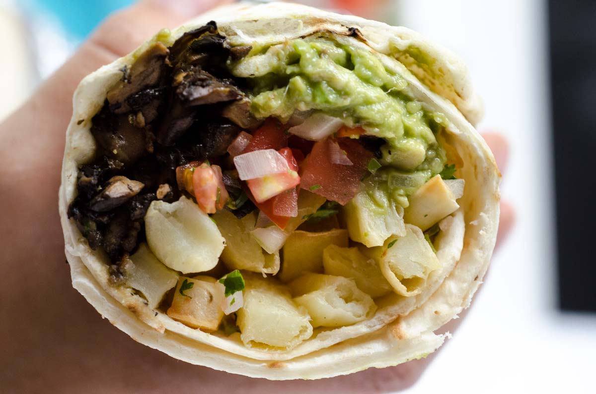 Closeup of a cut side of a vegan California burrito.