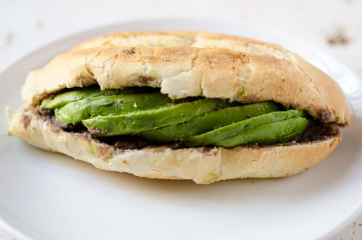 A torta split open containing avocado slices.