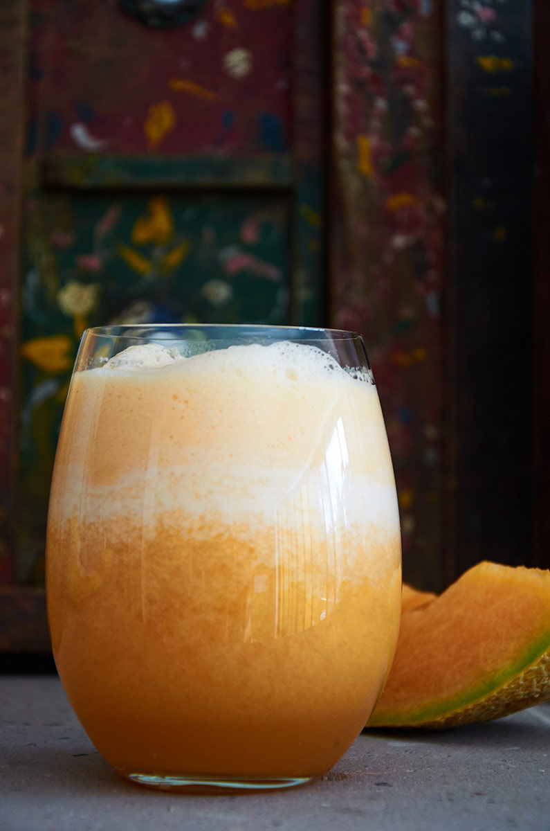 Close up of a glass filled with cantaloupe agua fresca.