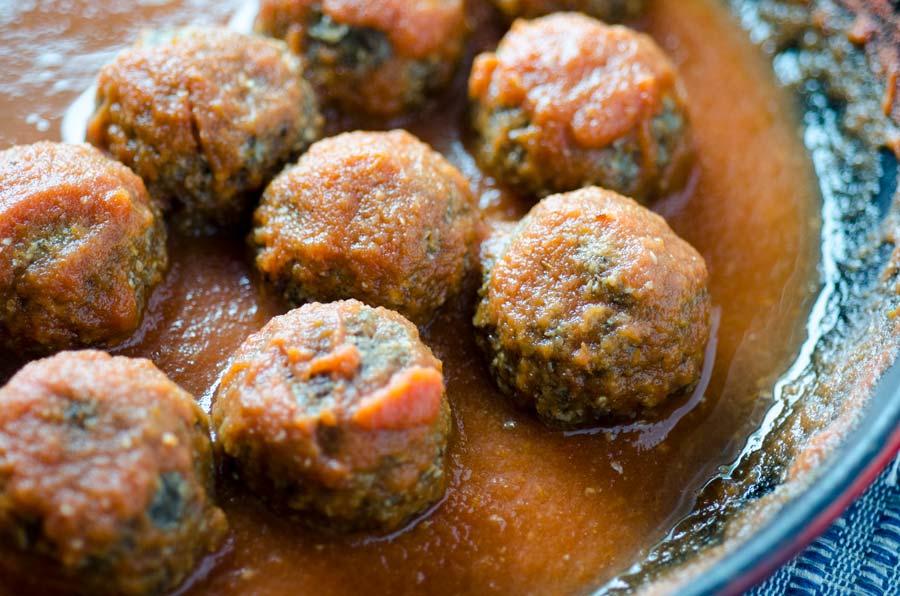 Tofu meatballs with red sauce in a saucepan.