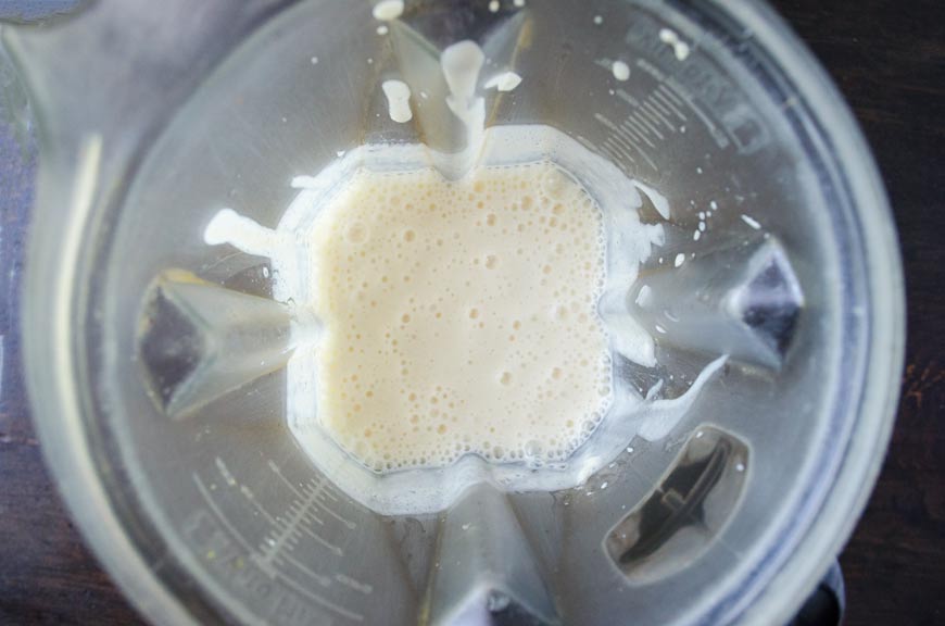 Top view of tofu and milk blended in a blender jar.