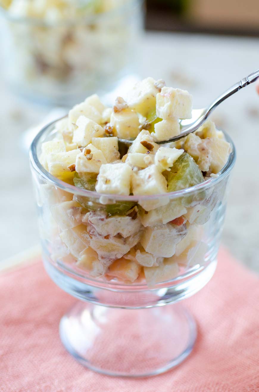 Mexican Christmas Apple Salad in a glass cup on top of a peach colored napkin.