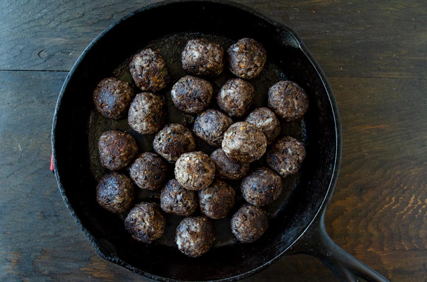 Vegan mushroom black bean meatballs in a cast iron pan.