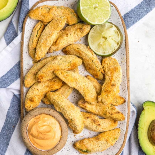 avocado fries on a large oval plate surrounded by a blue and white towel