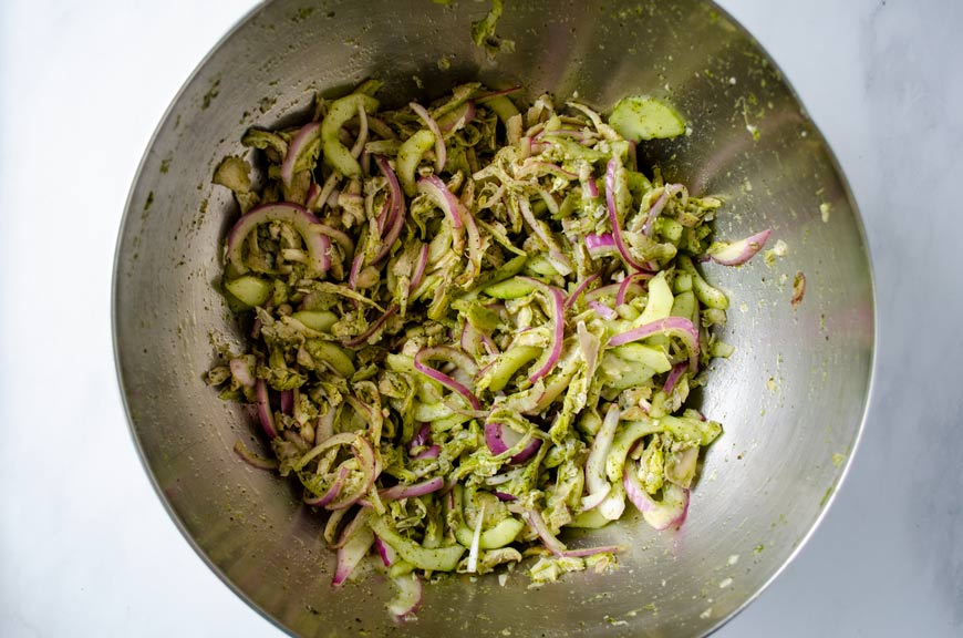 Mushrooms added to salsa, cucumber-onion mixture in a large stainless steel bowl.