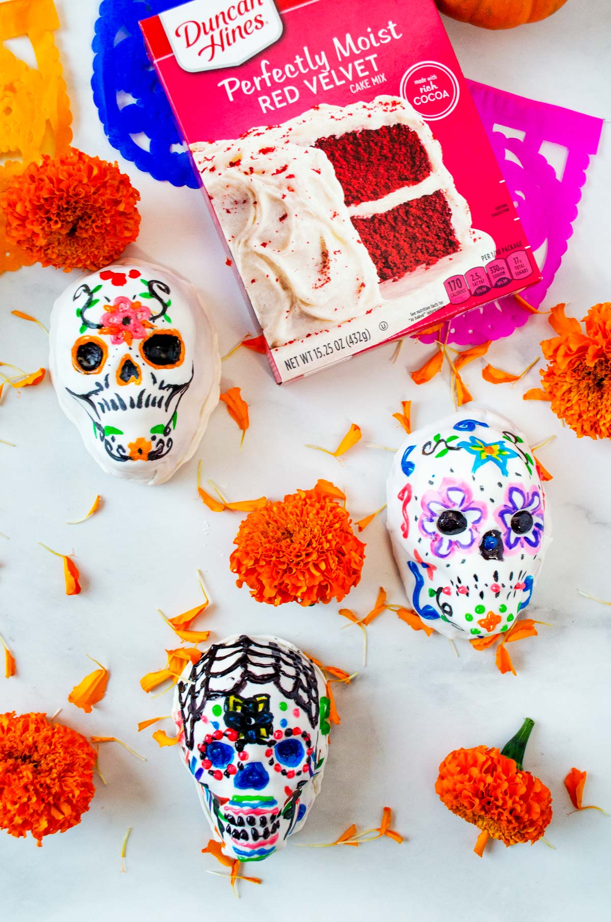 3 cake skulls on a marble background with flowers