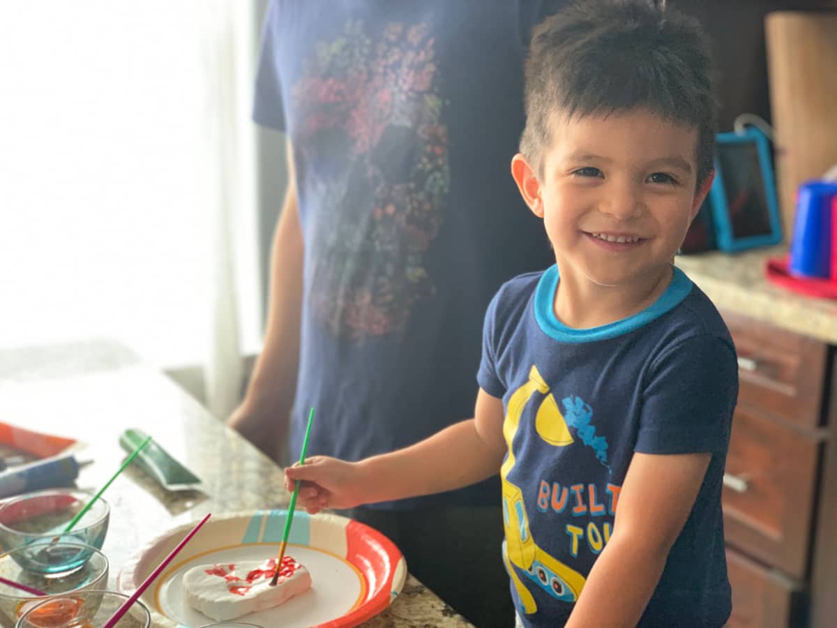 little boy decoratins a sugar skull