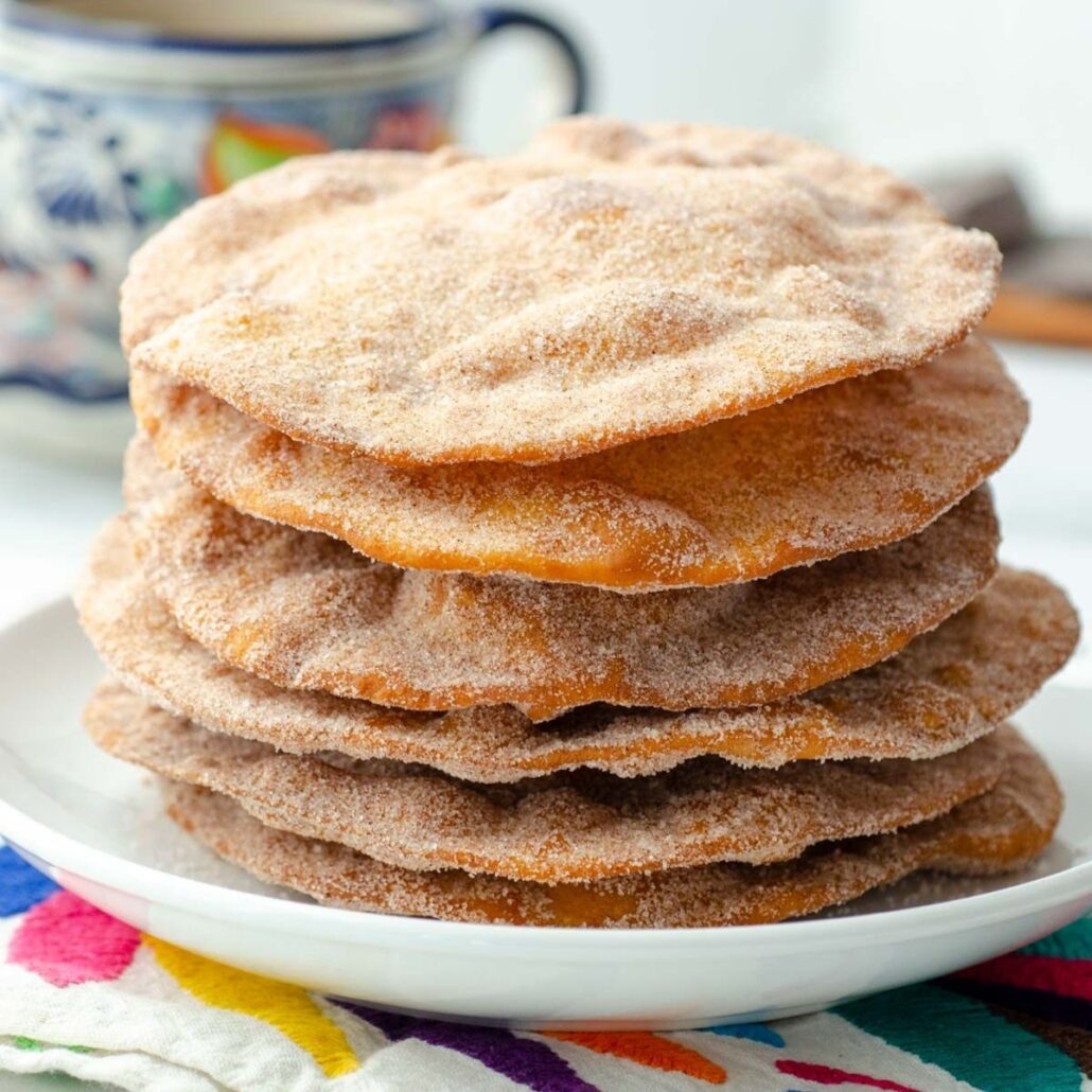 stack of buñuelos on a white plate