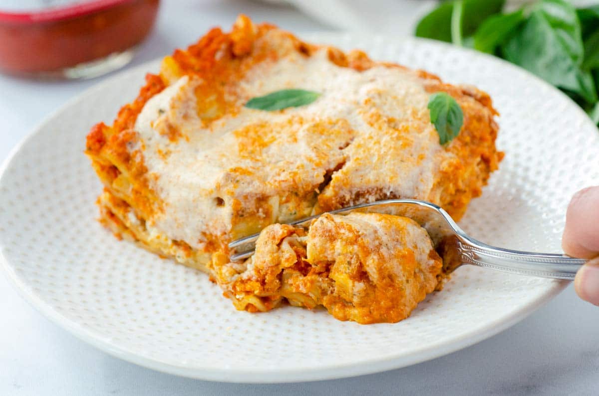 fork cutting into a piece of lasagna