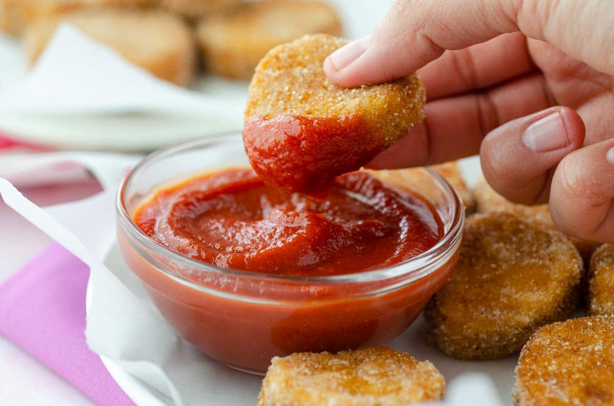 closeup of nugget being dipped into ketchup