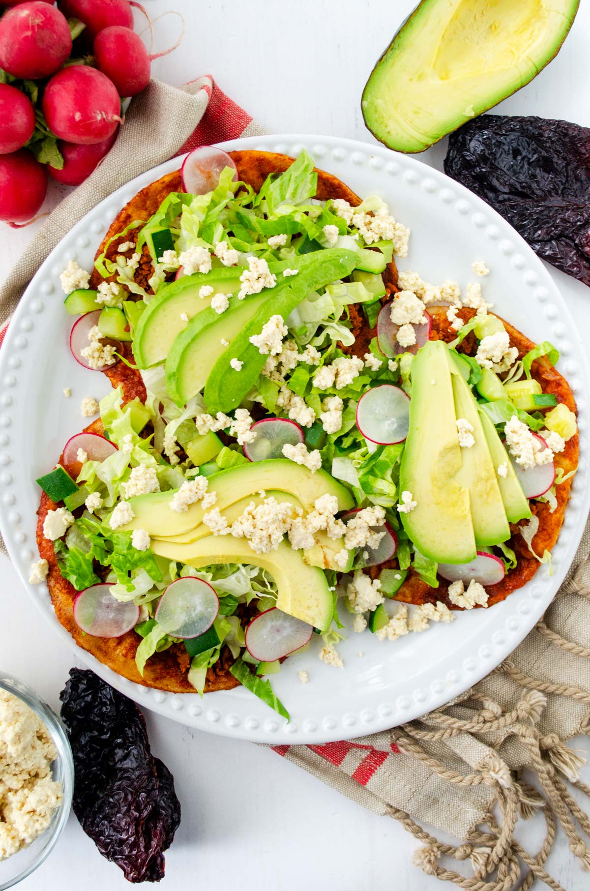 enchiladas de suelo on a white plate on top of a brown and red striped towel