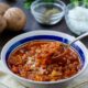 a bowl of vegan menudo with a lifted spoon