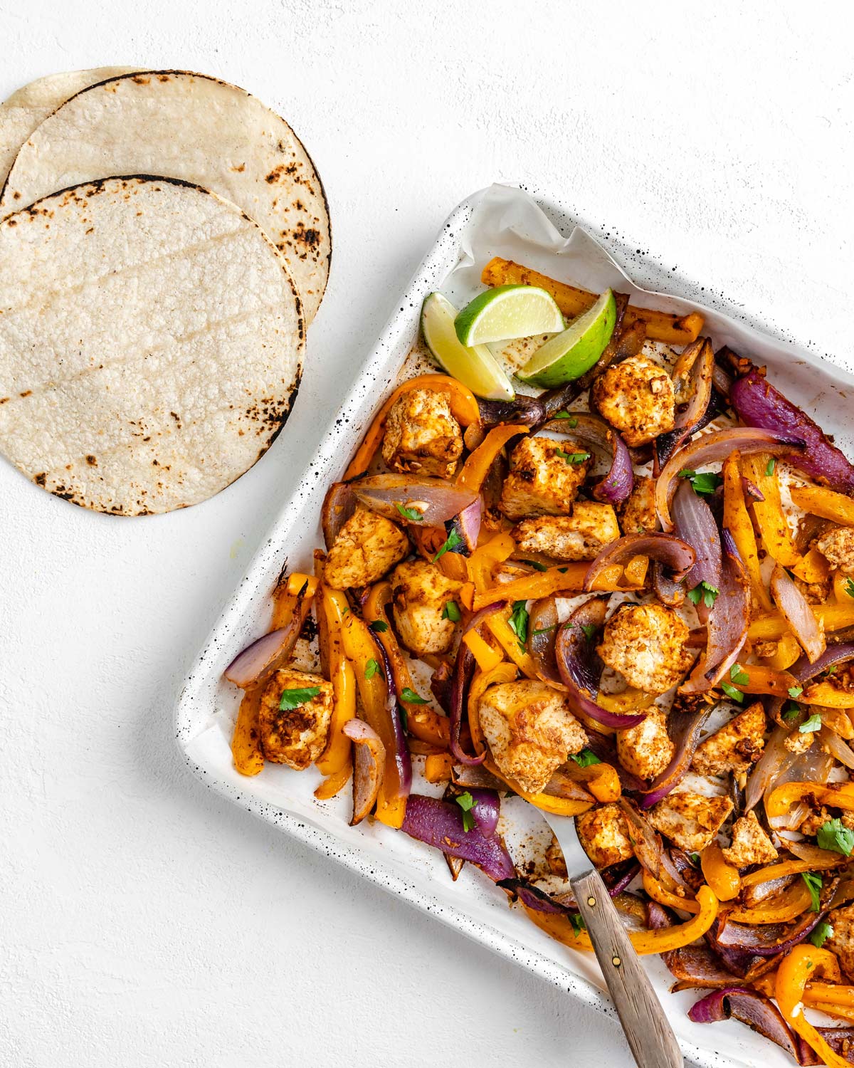 sheet pan of tofu fajitas and tortillas