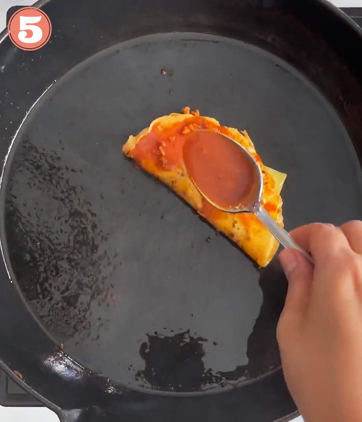 a spoon of sauce poured over birria quesadilla