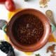 clay pot of mole poblano surrounded by ingredients