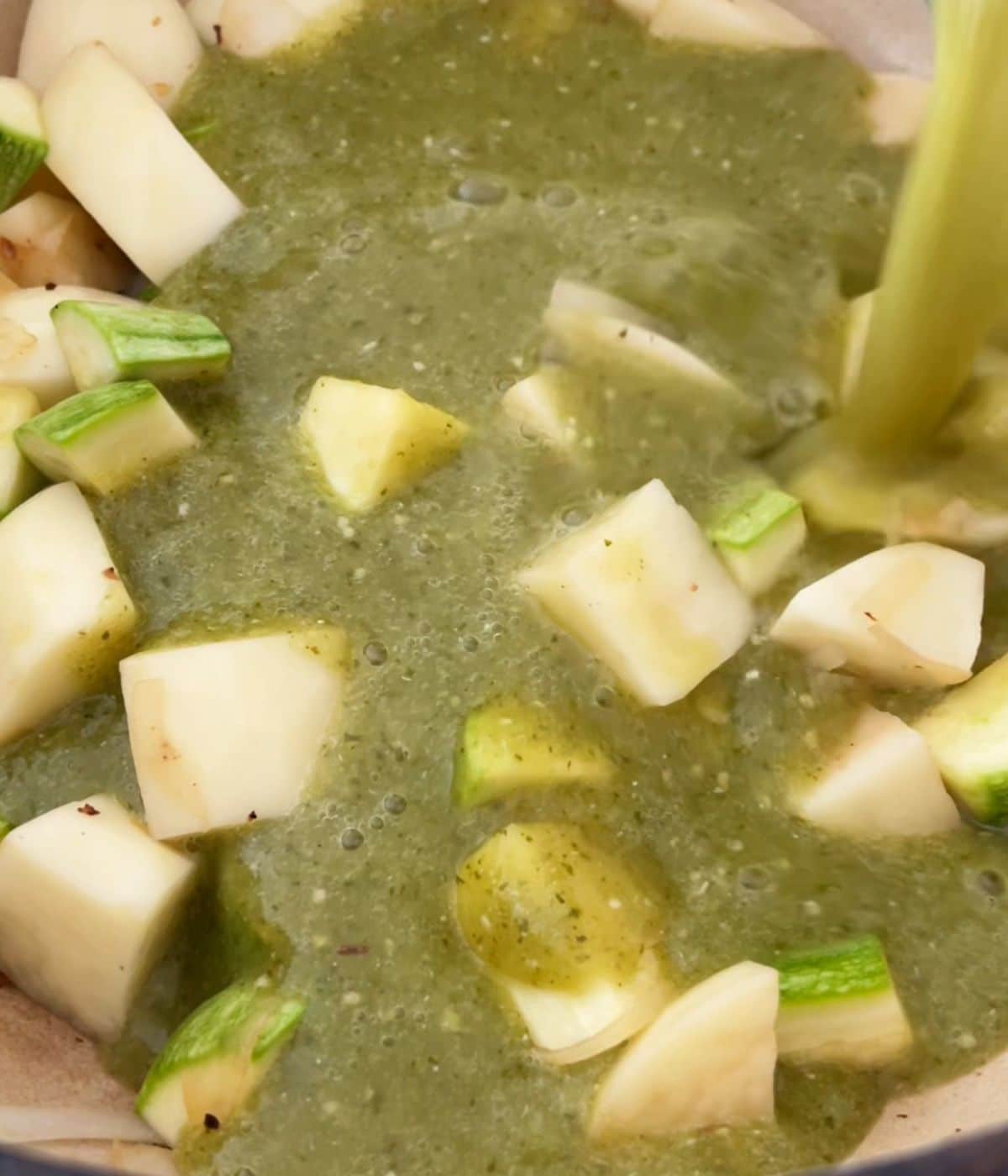 Salsa verde poured in the pot with the vegetables.