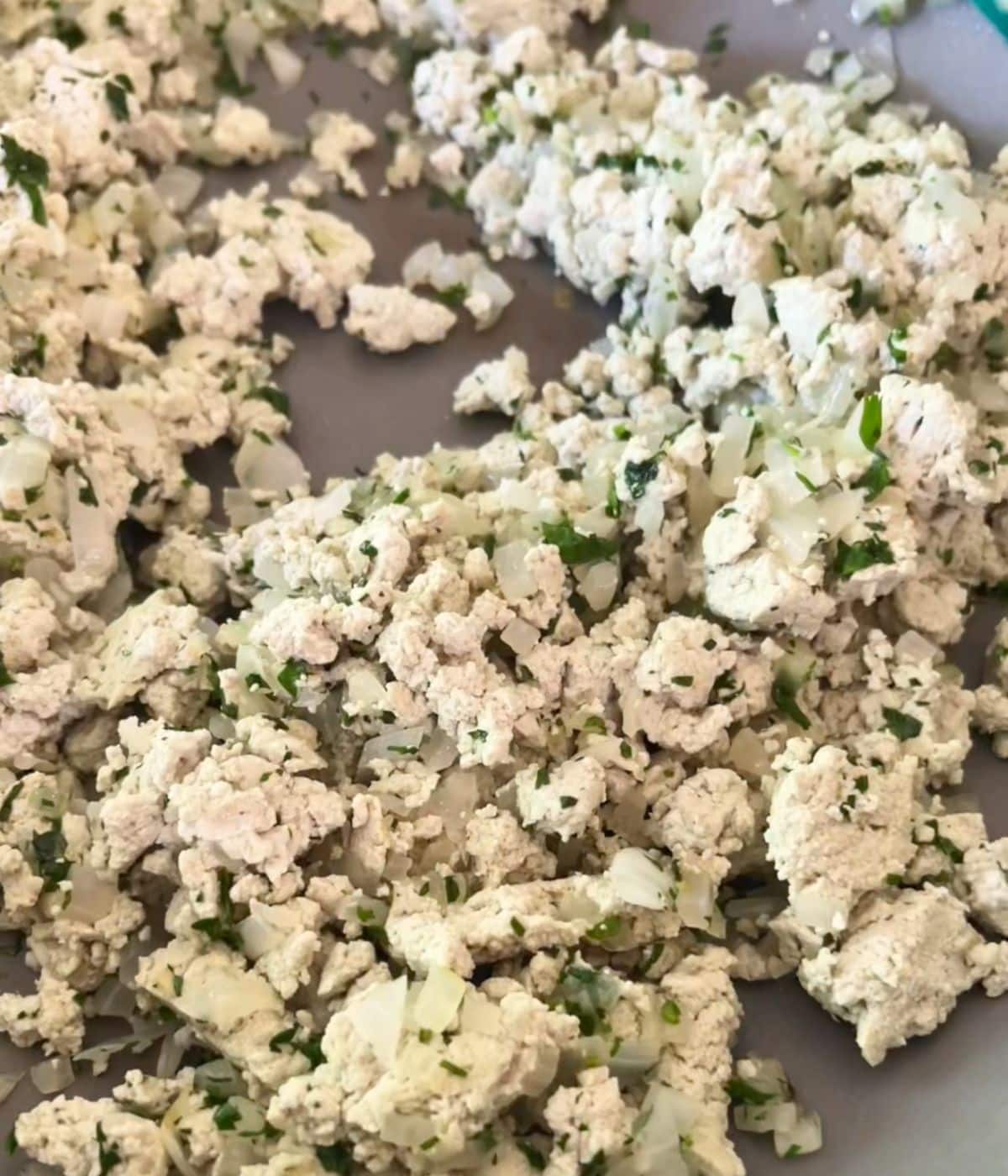 Pumpkin cheese with onion, and cilantro in a skillet.