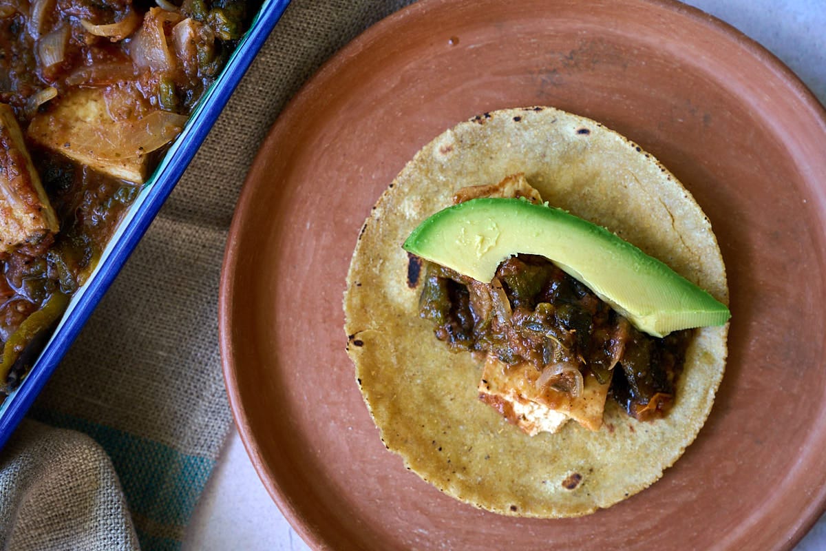 A rajas con queso taco on a clay plate.