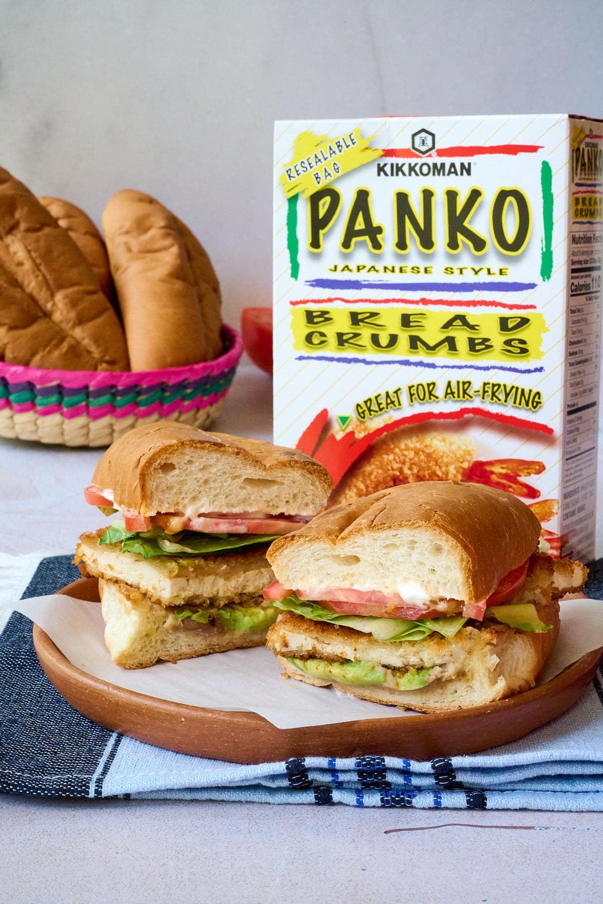 Torta de milanesa on a clay plate on top of a blue napkin.