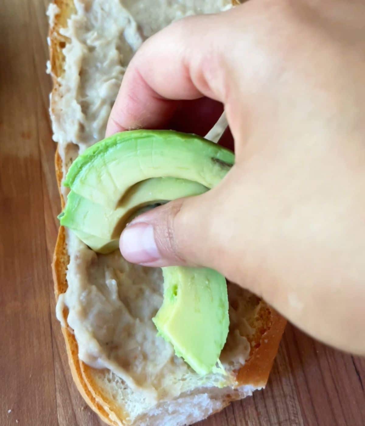 Avocado slices on top of toast with beans.